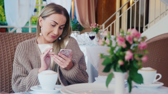 Stylish Good Looking Woman Uses a Smartphone