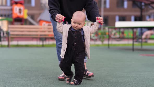 Baby Boy Holding Hands His Mom and Walking Together at the Playground