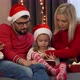 Family Choose Christmas Gifts in Online Store By Tablet Next to Christmas Tree - VideoHive Item for Sale