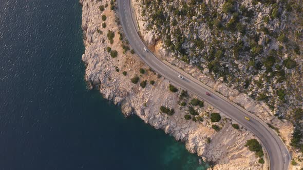 Aerial View of Serpentine Road Near Green Mountain and Blue Sea