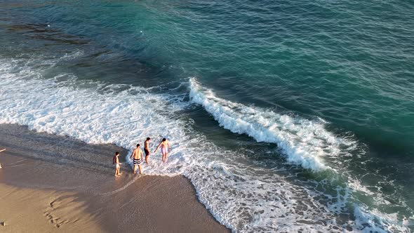 Friends play on the sea waves of the beach aerial view 4 K