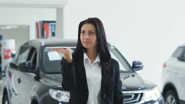 Image for Graphic Implements. Fashionable Girl in the Auto Show Holds a Tablet in Hand