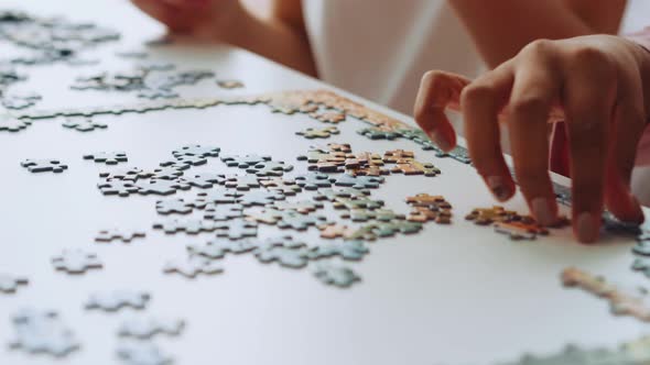 Two girls do jigsaw puzzles at home