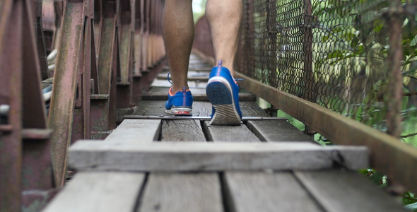 Legs Walking On Wood Bridge