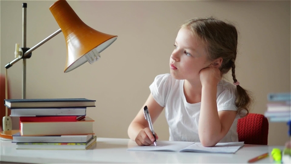 Little Schoolgirl Learns Lessons, Thoughtful Child Doing Homework