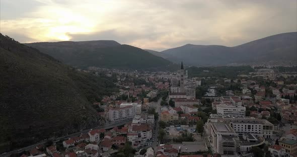 Aerial footage of Mostar in Bosnia and Herzegovina. mountainous hills in the distance and old town b