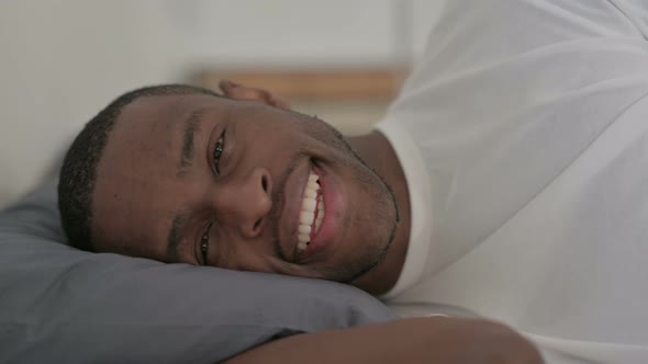 Happy African Man Laying in Bed Awake Smiling