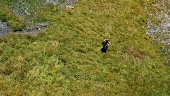 Aerial shot of a blonde girl hiking in the swiss alps