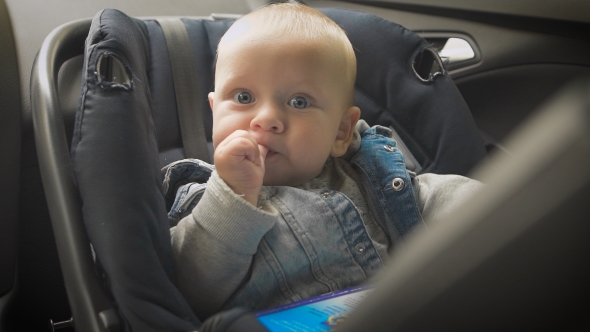 In Car Safety For Children. Little Boy Sitting In a Special Car Seat