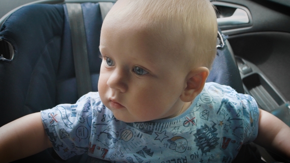 In Car Safety For Children. Little Boy Sitting In a Special Car Seat