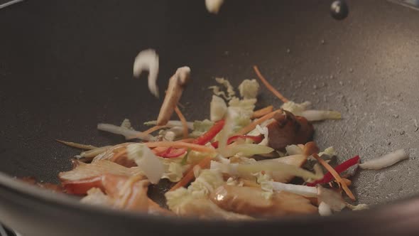 Cooking Chicken in a Pan in the Kitchen with Vegetables for Tasty Asian Wok