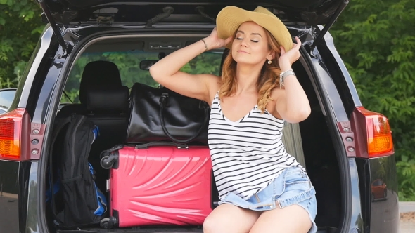 Girl In The Trunk Of a Car With Suitcases