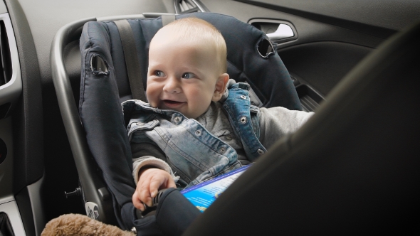 In Car Safety For Children. Little Boy Sitting In a Special Car Seat