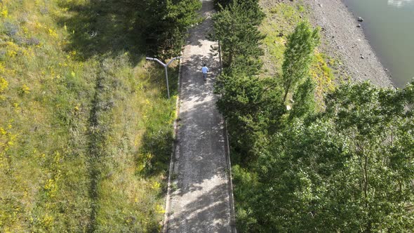 lonely man walking on the road among the trees