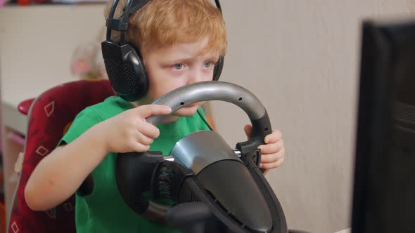 Little Boy Playing On Car Simulator