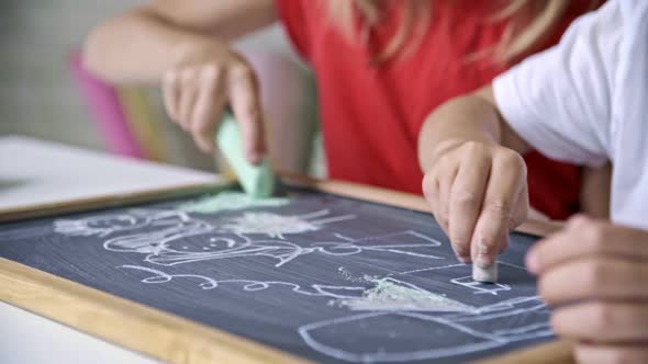 Children Drawing with Chalk on Blackboard