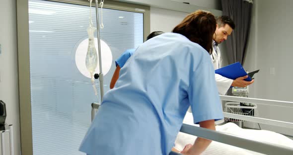 Doctors placing an oxygen mask and adjusting a iv drip to patient in emergency room