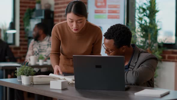 Business People Looking at Documents Charts and Laptop