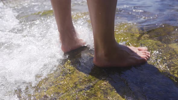 Bare feet touch the sea water.