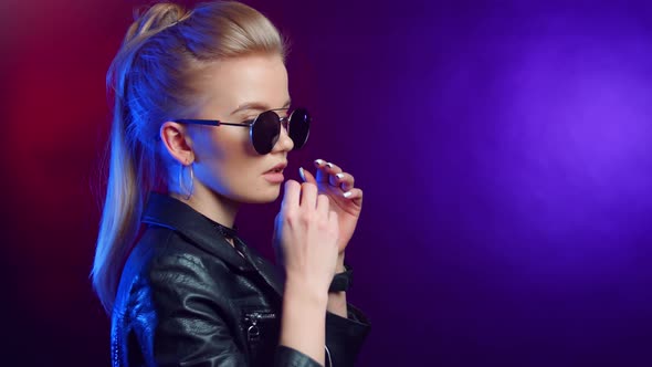 Fashionable Young Blonde Rock Star Girl in Sunglasses Dancing