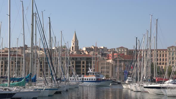 A yacht sailing by anchored boats