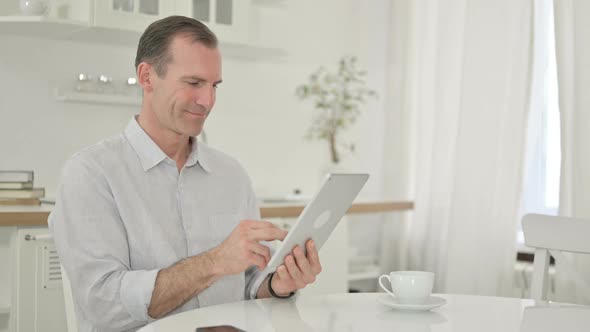 Middle Aged Man Using Tablet at Home 