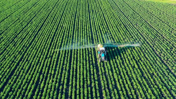 Green Field Is Getting Fertilized By an Agricultural Machine