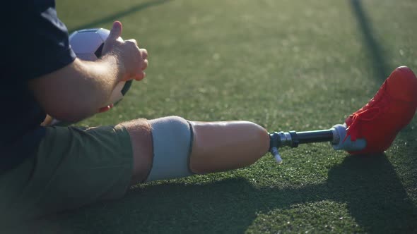 Closeup Artificial Leg of Unrecognizable Sportsman on Green Stadium Grass Outdoors