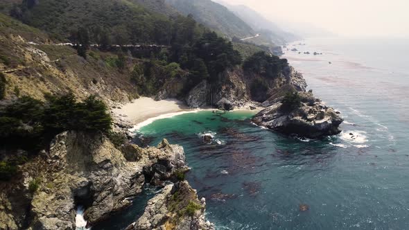 Aerial view of coastal rock formation with an dense pine tree forest, U.S.A.