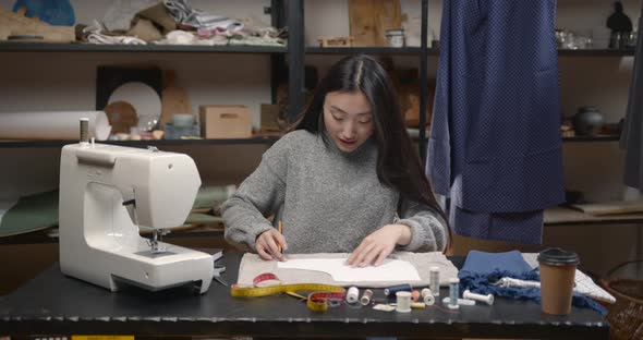 Professional Young Female Tailor Working in Workshop