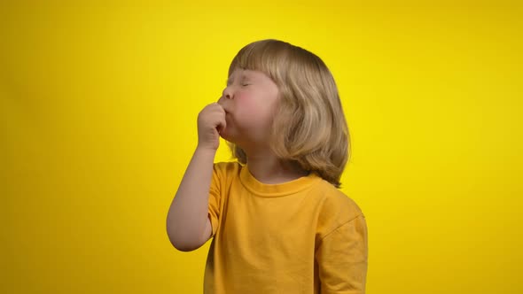 A Cute Little Girl with Short Hair is Blowing in a Whistle with Closed Eyes