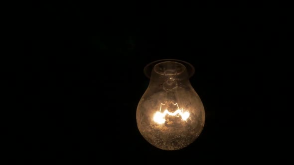 Slow motion dusty light bulb swings  in the dark 1920X1080 HD video - Light bulb swinging  horror sc