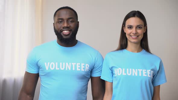 Mixed-Race Volunteers Standing With Hands Crossed in Rehabilitation Center, Help