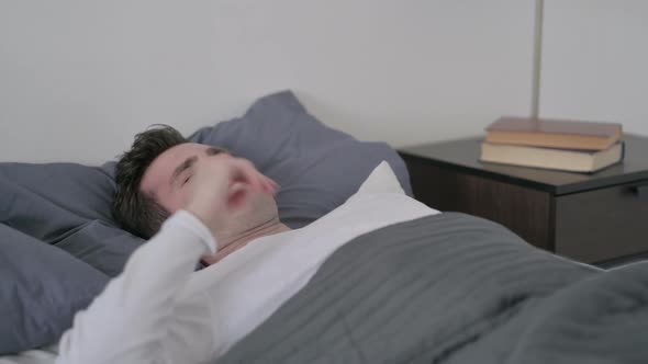 Man Having Headache While Sleeping in Bed