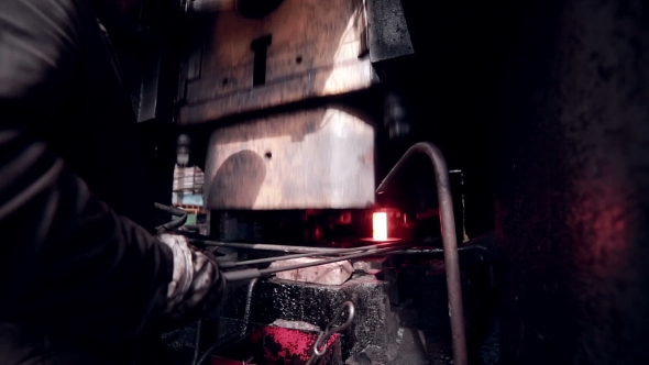 Worker Operates With Automated Metalworking Machine At a Metal Forging Factory.