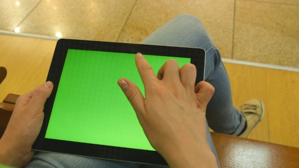 Young Girl Sitting At Bench In Shopping Mall And Working With Tablet. Female Hands Using Tablet Pc