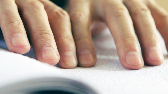 Male Hands Reading Braille.