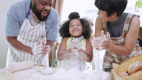 Close up of enjoy African American girl thresh dough with parents together