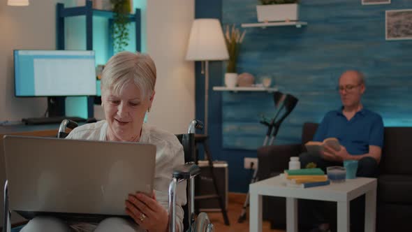 Senior Woman with Physical Disability Looking at Laptop Screen