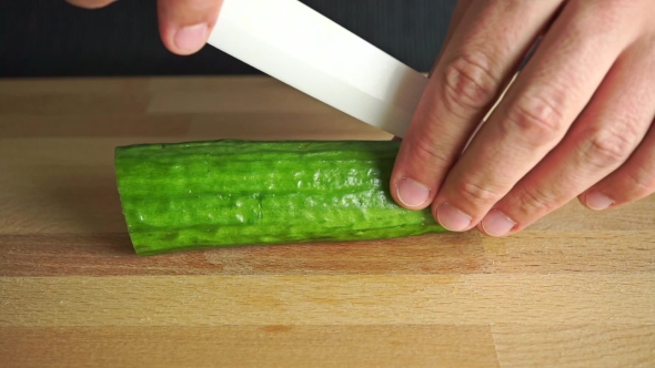 Man Cutting Cucumber Longitudinally