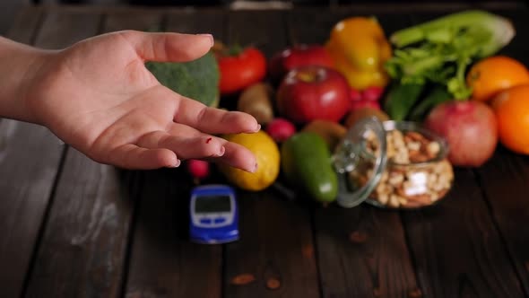 Woman with Diabetes Measuring Blood Sugar Level on the Background of Fruits