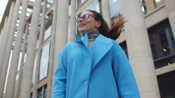 Happy Positive Young Businesswoman in Blue Coat Standing Outdoors Business Center