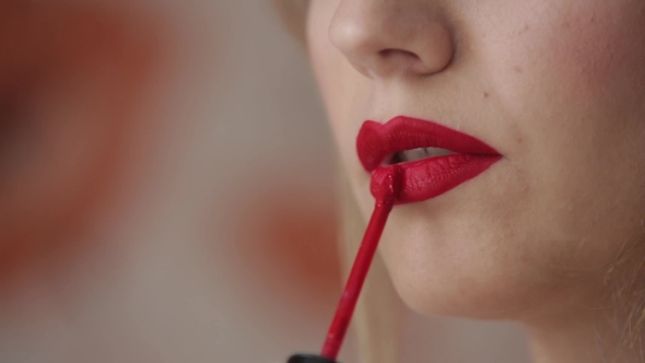 Beautiful Woman Paints Her Lips 