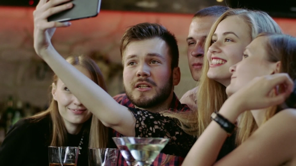 Company Of Young People Is Taking Selfie In The Bar
