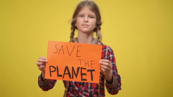 Save the Planet Banner in Teenage Caucasian Hands with Blurred Girl at Yellow Background Turning