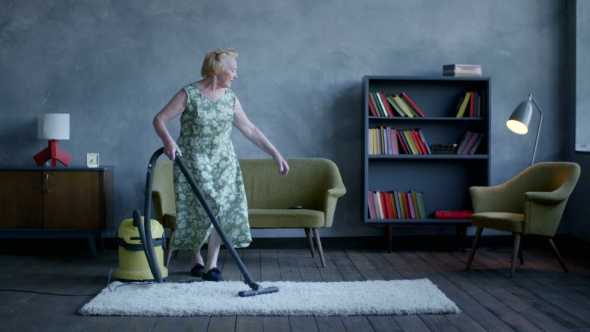 Happy Elderly Woman Gave Up The Cleaning And Sat Down To Relax And Watch TV