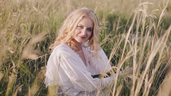 Girl Sitting In The Grass And Looking At The Camera