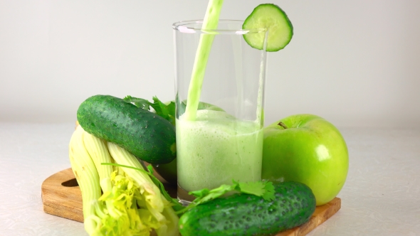 Pouring Green Smoothy In a Glass. Apple, Cucumber And Celery.