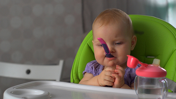 The Child Sits and Plays With the Spoon