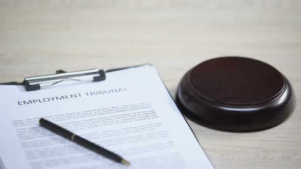 Employment Tribunal Document on Table, Gavel Striking on Sound Block, Dispute